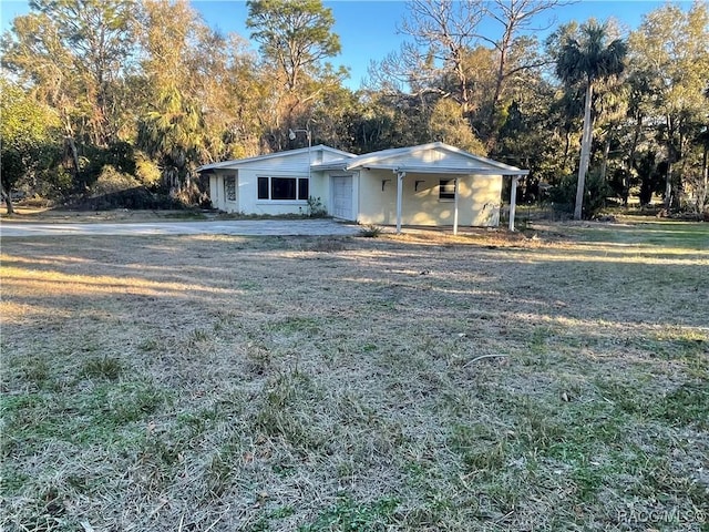 view of front of property featuring a front lawn and a carport