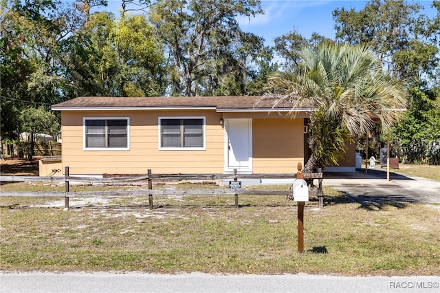 view of front of house featuring entry steps, a front lawn, and fence