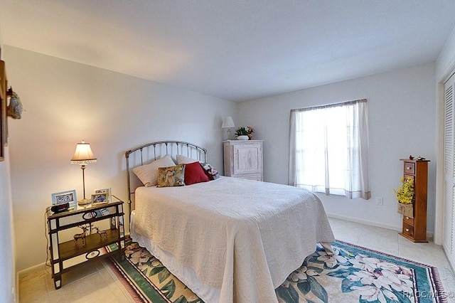 bedroom with light tile patterned flooring and a closet