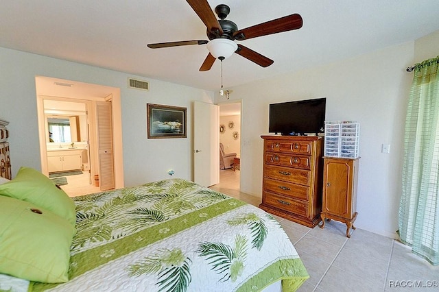 tiled bedroom with ensuite bath and ceiling fan