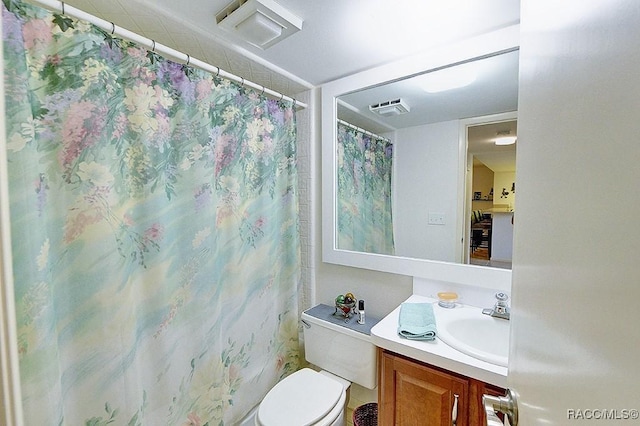 bathroom featuring vanity, toilet, and walk in shower