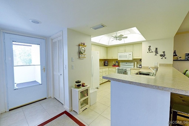 kitchen featuring sink, kitchen peninsula, white appliances, a breakfast bar, and light tile patterned flooring