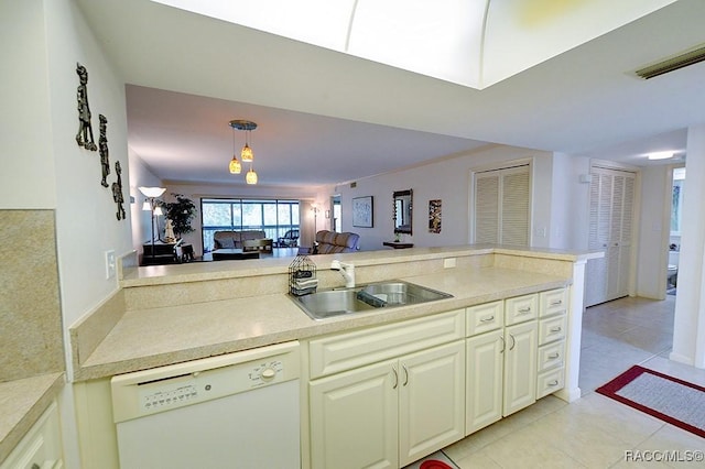 kitchen with white dishwasher, light tile patterned floors, sink, and hanging light fixtures