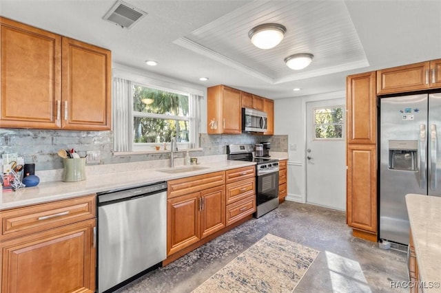 kitchen with stainless steel appliances, decorative backsplash, sink, ornamental molding, and a tray ceiling