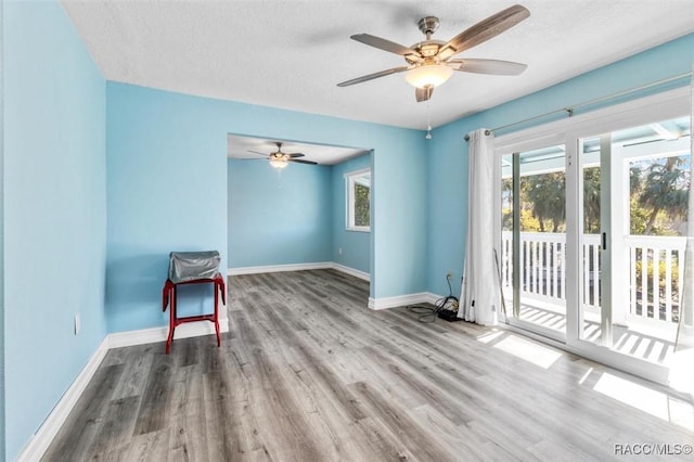 empty room featuring a textured ceiling, ceiling fan, and light wood-type flooring