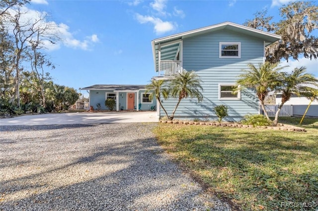 front of property with a front lawn and a balcony