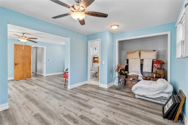 interior space featuring ceiling fan, ensuite bathroom, and light hardwood / wood-style flooring