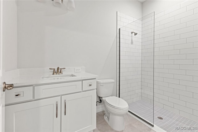 bathroom with tile patterned flooring, vanity, tiled shower, and toilet