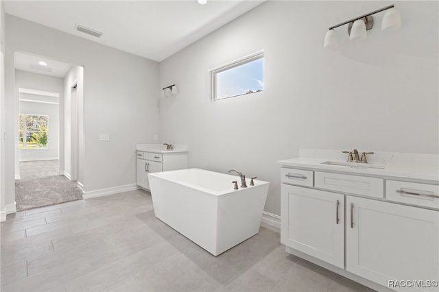 bathroom with vanity and a tub to relax in