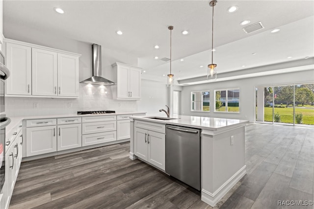 kitchen featuring appliances with stainless steel finishes, wall chimney exhaust hood, dark wood-type flooring, sink, and white cabinets