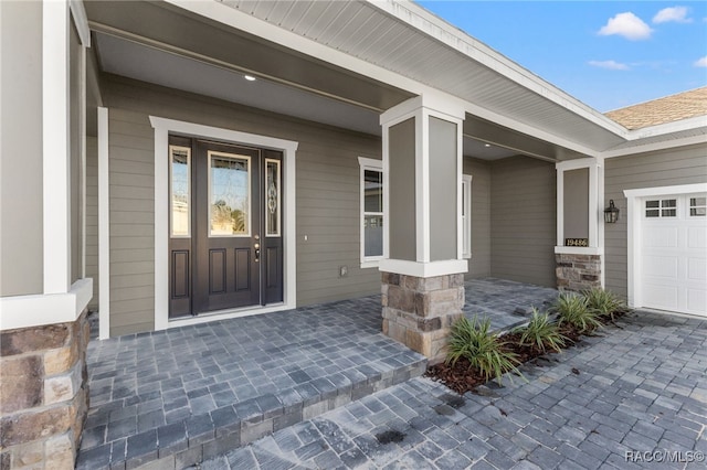 doorway to property featuring a porch and a garage