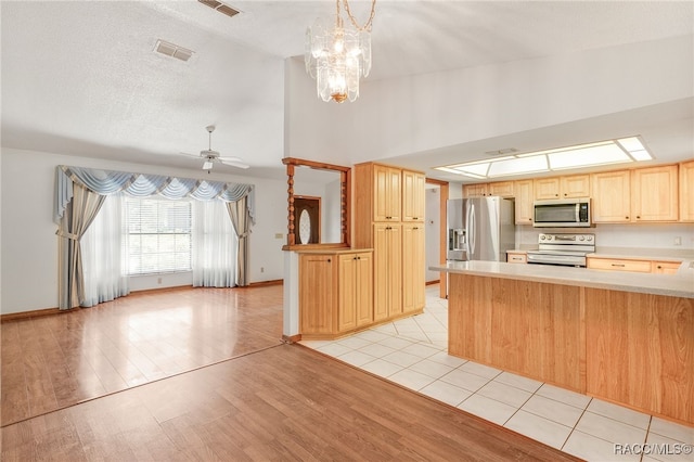 262 N Indianapolis Ave, Hernando, FL 34442 - kitchen featuring stainless steel appliances, light brown cabinets, light countertops, a peninsula, and light wood-style floors