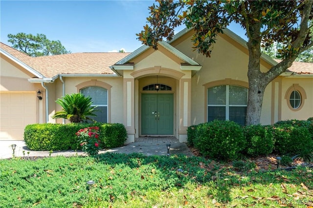 4690 W Tomahawk Dr, Beverly Hills, FL 34465 - entrance to property with stucco siding, a garage, and a shingled roof