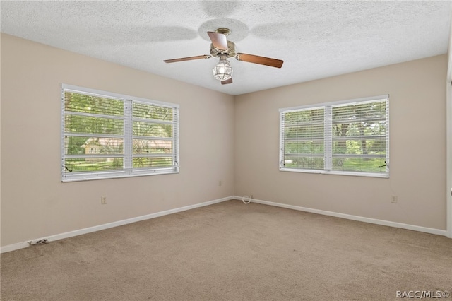 empty room featuring light carpet, ceiling fan, and a textured ceiling