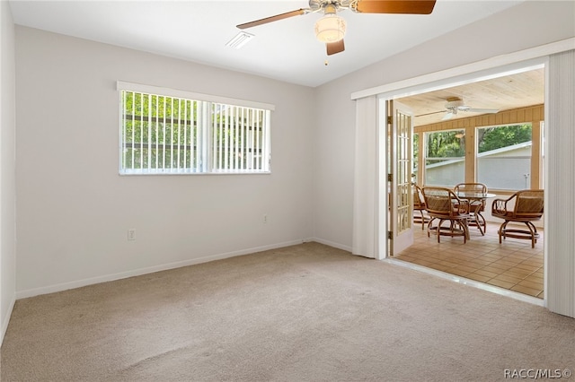 carpeted spare room featuring plenty of natural light and vaulted ceiling