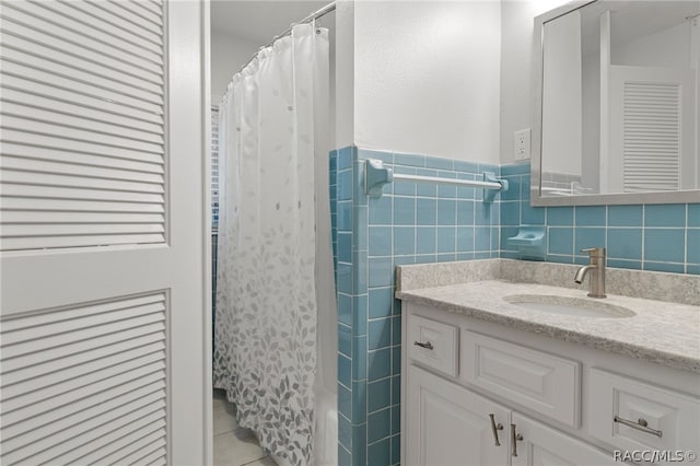 bathroom featuring tile patterned flooring, vanity, and tile walls