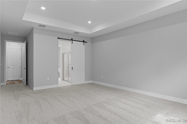 43 Bells Of Ireland Ct, Homosassa, FL 34446 - unfurnished bedroom with a barn door, a tray ceiling, light carpet, recessed lighting, and baseboards