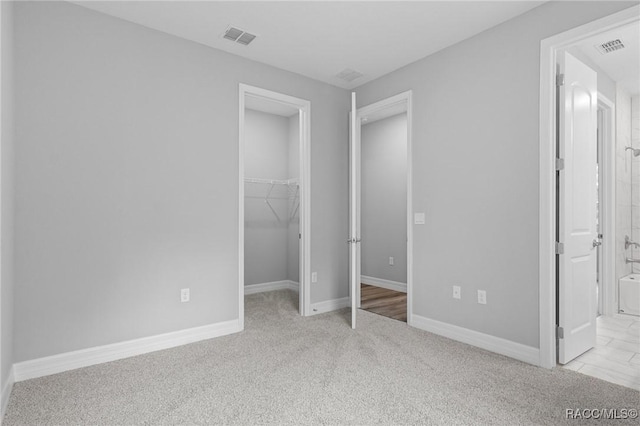 43 Bells Of Ireland Ct, Homosassa, FL 34446 - unfurnished bedroom featuring a spacious closet, a closet, carpet flooring, ensuite bath, and baseboards