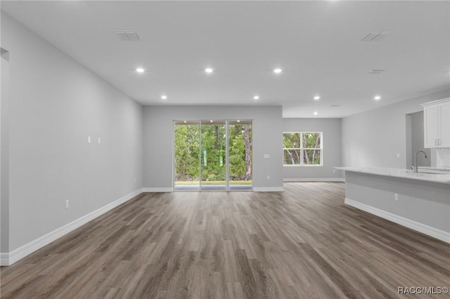 43 Bells Of Ireland Ct, Homosassa, FL 34446 - unfurnished living room featuring wood finished floors, recessed lighting, baseboards, and a sink