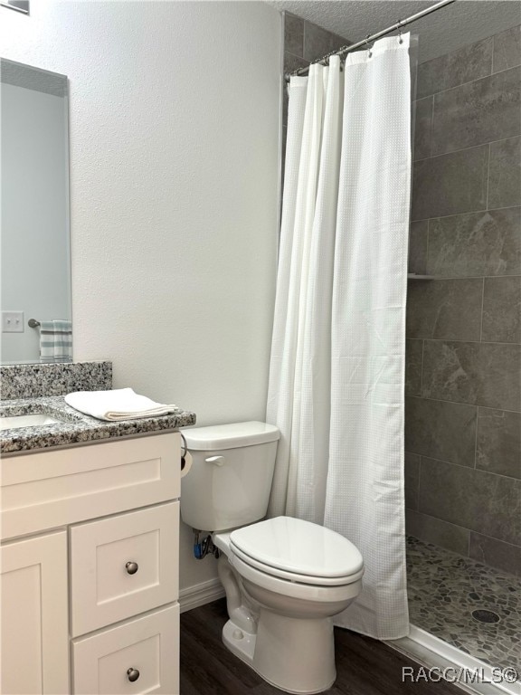 bathroom with hardwood / wood-style floors, vanity, toilet, and a shower with shower curtain