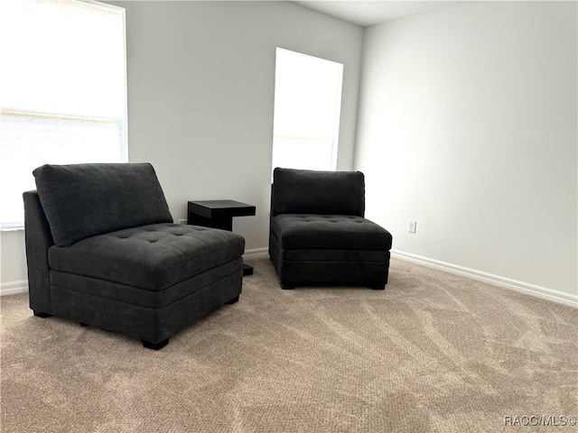 sitting room featuring light colored carpet