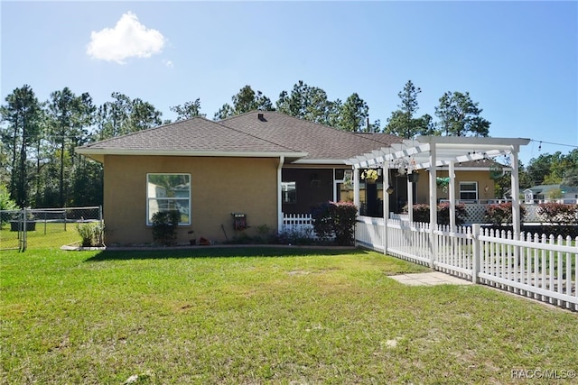 back of house featuring a pergola and a lawn