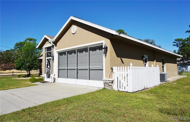 view of side of home with a garage, a yard, and central AC