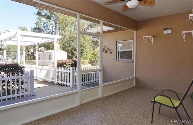 unfurnished sunroom featuring ceiling fan