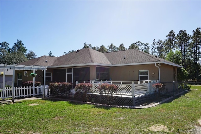 rear view of property featuring a lawn