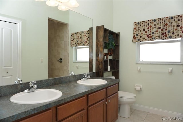 bathroom with tile patterned flooring, vanity, toilet, and plenty of natural light