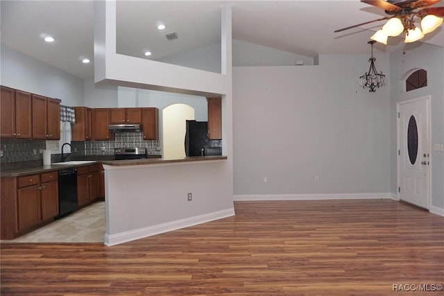 kitchen featuring kitchen peninsula, tasteful backsplash, sink, black appliances, and high vaulted ceiling