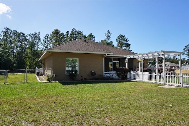 back of house featuring a pergola and a lawn