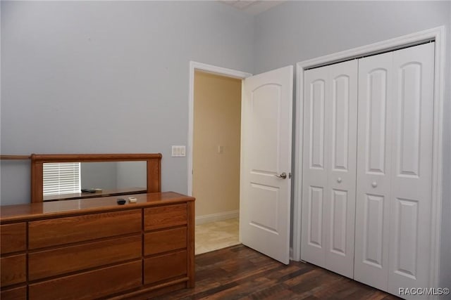 unfurnished bedroom with dark hardwood / wood-style flooring and a closet