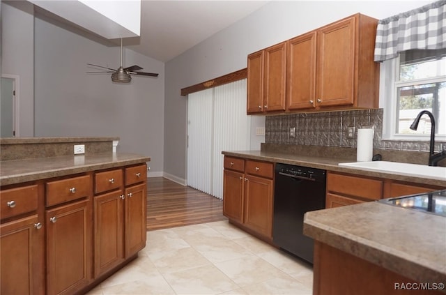 kitchen featuring dishwasher, lofted ceiling, sink, ceiling fan, and decorative backsplash