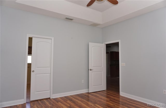 unfurnished bedroom featuring ceiling fan and dark hardwood / wood-style flooring