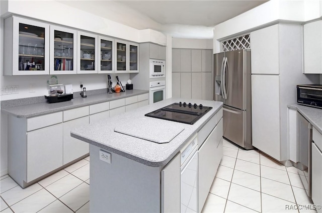 270 E Keller Ct, Hernando, FL 34442 - kitchen with white appliances, a kitchen island, light tile patterned floors, and light countertops