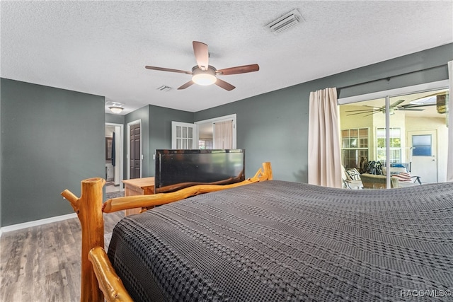 bedroom featuring hardwood / wood-style floors, a textured ceiling, and ceiling fan