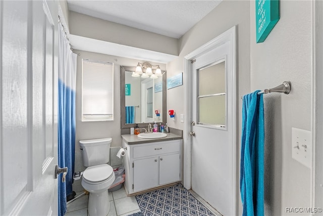 bathroom with tile patterned flooring, vanity, toilet, and a textured ceiling