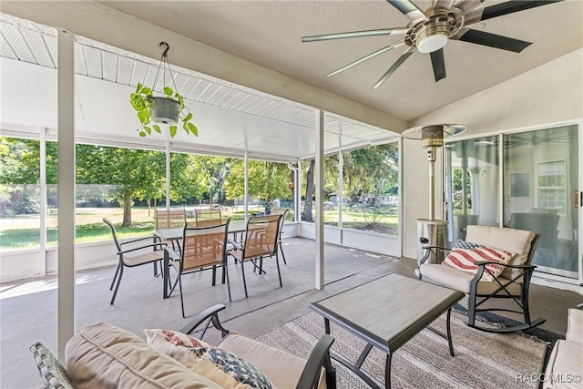 sunroom / solarium featuring ceiling fan, a healthy amount of sunlight, and lofted ceiling