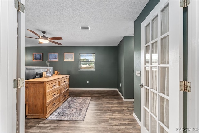 interior space with a textured ceiling and dark hardwood / wood-style floors