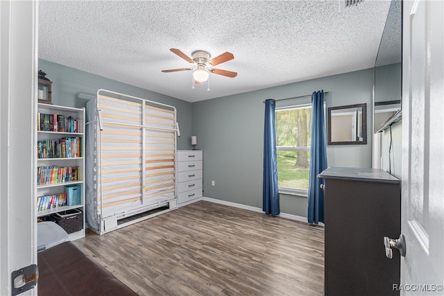 unfurnished bedroom featuring ceiling fan, dark hardwood / wood-style flooring, and a textured ceiling