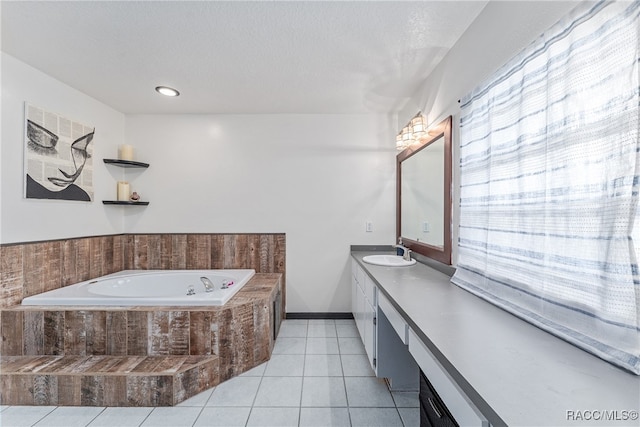 bathroom featuring tile patterned flooring, vanity, and tiled tub