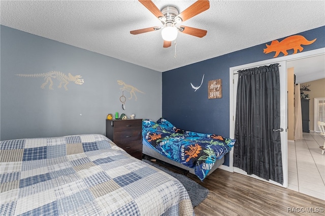 bedroom featuring hardwood / wood-style floors, ceiling fan, a textured ceiling, and a closet