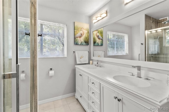 bathroom with tile patterned floors, a wealth of natural light, a shower with door, and vanity