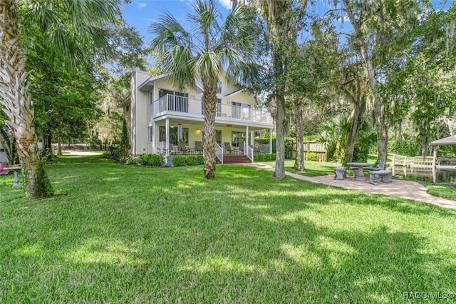 view of yard with a balcony and a porch