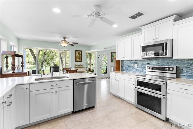 kitchen with decorative backsplash, white cabinetry, sink, and appliances with stainless steel finishes