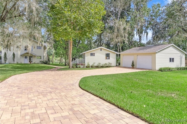 view of front of home featuring a garage, an outdoor structure, and a front yard