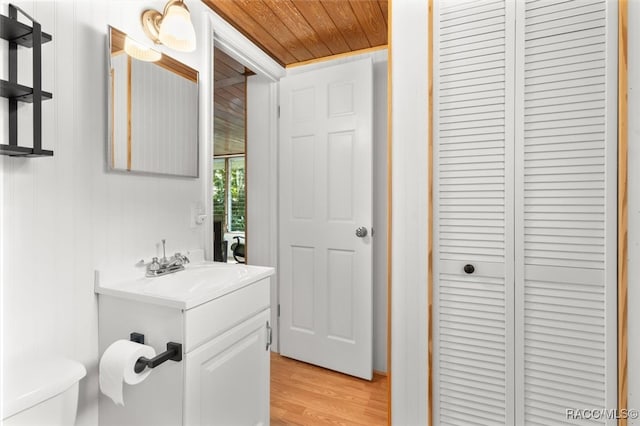 bathroom featuring vanity, wood-type flooring, and toilet