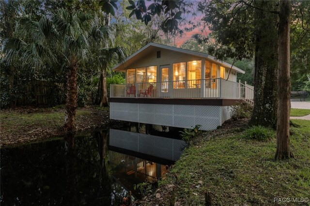 property exterior at dusk featuring a wooden deck