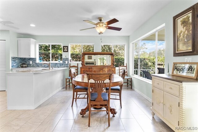 tiled dining room with plenty of natural light and ceiling fan